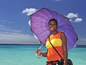 Dominikanische Republik, Frau mit Sonnenshirm am Strand, Latin America Tours