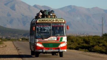 Argentinien, bunter Bus auf Überlandstrasse in der Region Humahuaca, Latin America Tours