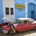 Kuba, Automechaniker repariert roten Oldtimer, Latin America Tours, Reisen