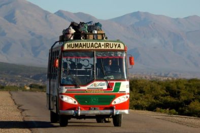 Argentinien, bunter Bus auf Überlandstrasse in der Region Humahuaca, Latin America Tours